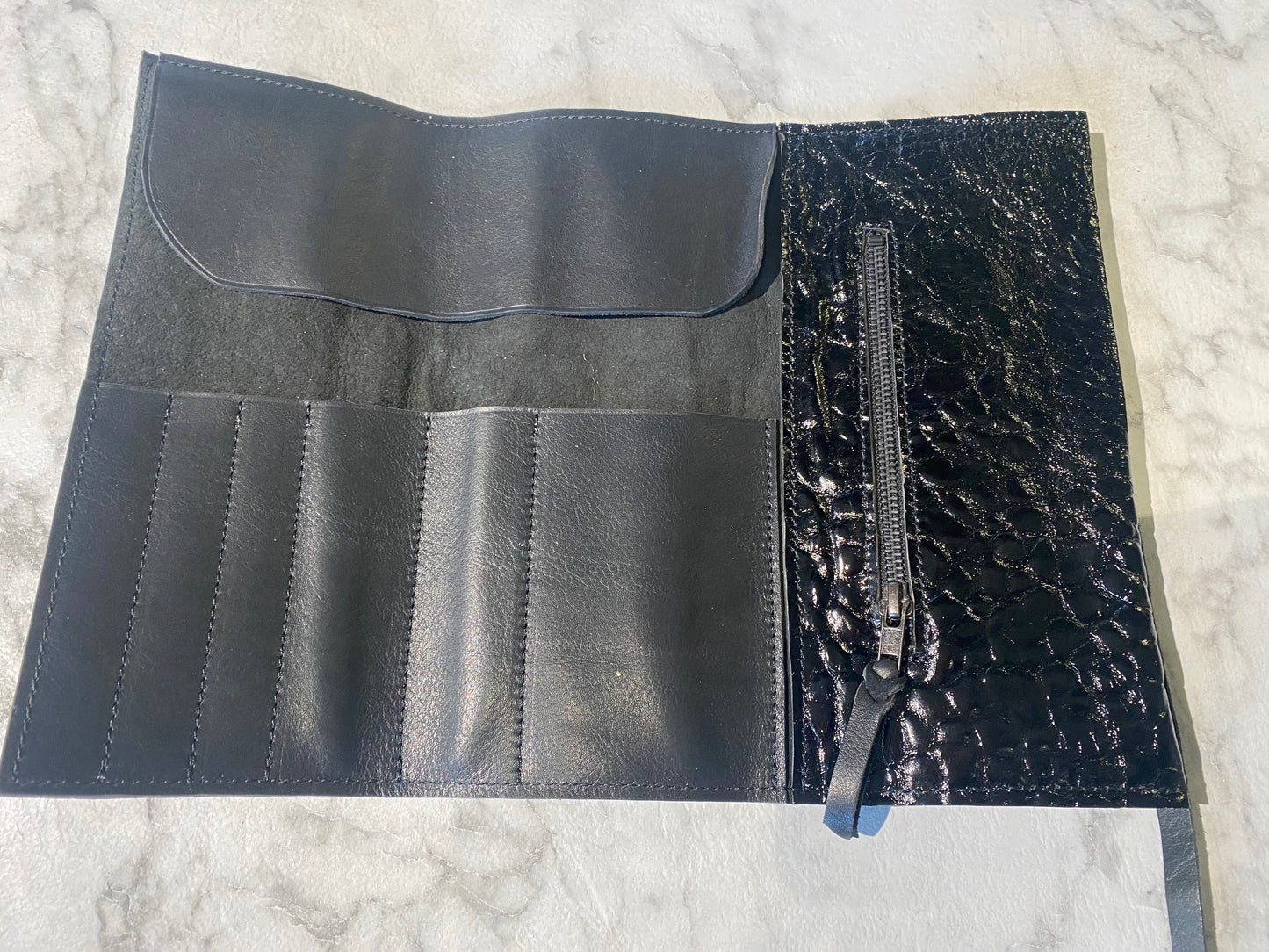 Pochette à maquillage noir brillant.